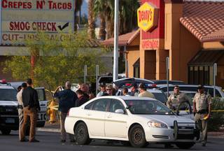 Metro Police officers and investigators gather at the 300 block of Nellis Boulevard, near Stewart Avenue, after a shooting Tuesday, May 8, 2018.