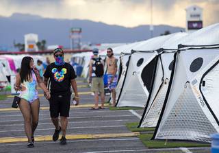 A couple walks by tents at Camp EDC at the Las Vegas Motor Speedway Saturday, May 19, 2018. The campground has 3400 tents and 1100 RV spaces.