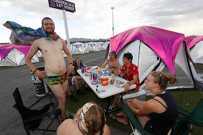 Ryan Morrison, left, of Calgary, Alberta, Canada has a meal with friends before heading to the Electric Daisy Carnival at Camp EDC at the Las Vegas Motor Speedway Saturday, May 19, 2018. The group drove 2100 miles in two days to attend the festival, they said.