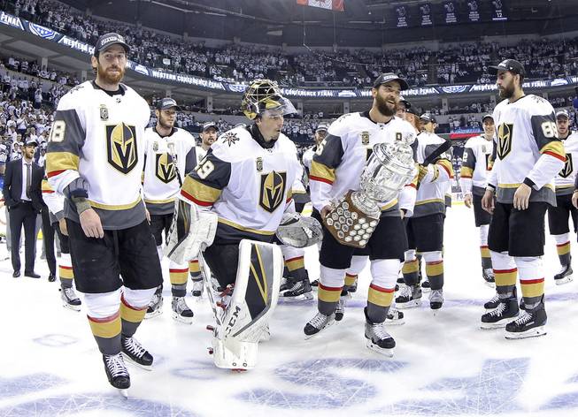Vegas Golden Knights' James Neal (18), Deryk Engelland (5), goaltender Marc-Andre Fleury (29) and the rest of the team celebrate after defeating the Winnipeg Jets during NHL Western Conference Finals, game 5, in Winnipeg, Sunday, May 20, 2018.