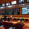 In this May 14, 2018, file photo, people make bets in the sports book at the South Point hotel and casino in Las Vegas. A day before New Jersey’s governor makes his state’s first legal wager on a sporting event, sports betting will be the main topic at a major gambling industry conference in Atlantic City. 