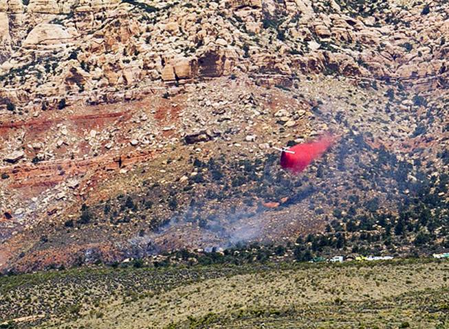 An airplane dumps fire retardant on a wildfire at Red Rock Canyon National Conservation Area on Friday, June 22, 2018.