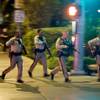 In this Oct. 1, 2017, file photo, police run toward the scene of a shooting near Mandalay Bay.