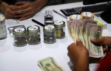 A customer buys marijuana at the Essence cannabis dispensary in Las Vegas, July 1, 2017. 