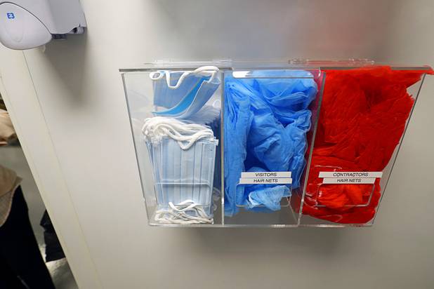 Hairnets and masks are stored near a grow room entrance at Oasis Biotech, an indoor microgreen and herb vertical farming facility, Wednesday, July 18, 2018.