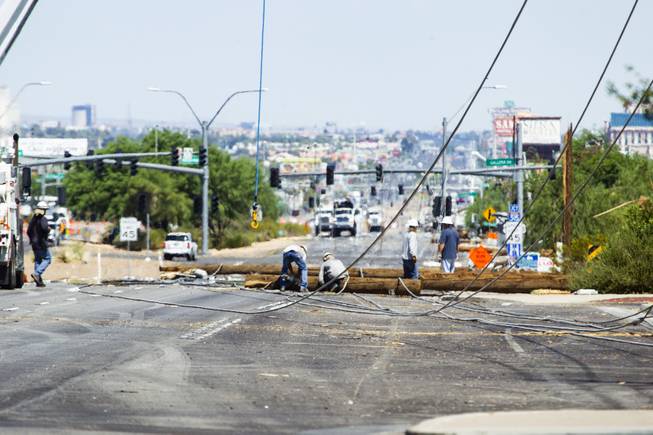 Workers clean up downed power lines on Boulder Highway between Russell and Sunset roads following a thunderstorm the previous night that brought high winds to the area, Friday, July 20, 2018.