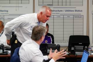 FBI agent Joe Dickey looks at FBI agent Michael Hill's computer screen during Table Top the Vote 2018, a national election cyber exercise that is being hosted by the U.S. Department of Homeland Security (DHS), Monday, Aug. 13, 2018. The purpose of the exercise is to assist DHS, state and local election stakeholders in identifying best practices and improving cyber incident planning, through simulation of realistic scenarios exploring impacts to voter confidence, voting operations, and the integrity of elections.