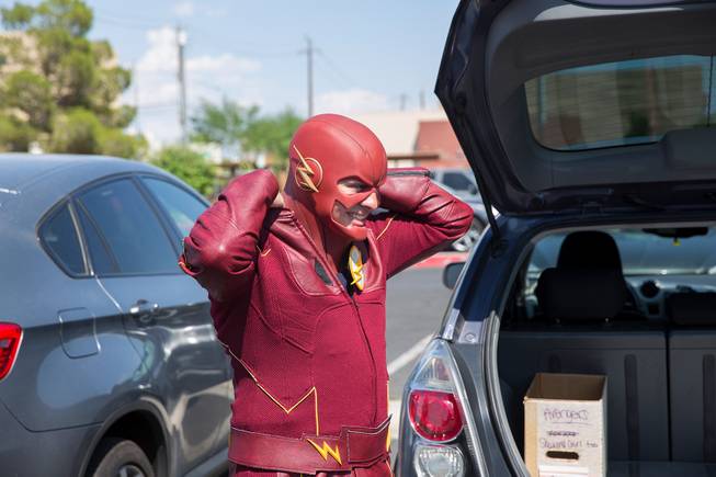 Chase Addison, of Critical Care Comics, puts on the final touches of his Flash costume as he prepares to deliver comic books and toys to kids at UMC's Children's Hospital, Sat Aug. 18, 2018.