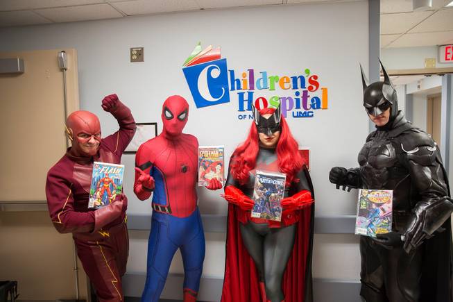 Critical Care Comics' Chase Addison, as The Flash, Michael Mutzhause, as Spider-Man, Lexi Kreuz, as Batwoman, and Tyler Moir, as Batman, pose for a photo at UMC's Children's Hospital as they deliver comic books and toys to kids, Saturday, Aug. 18, 2018.