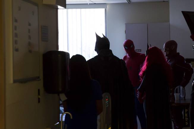 Critical Care Comics' freindly superheroes deliver comic books and toys to a sick child at UMC's Children's Hospital, Sat Aug. 18, 2018.