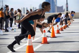 Asia Windley, foreground, and other women run an agility course during a Metro Police Women's Bootcamp on the top floor of the Metro Police parking garage Saturday, Aug. 25, 2018.