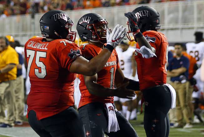 UNLV wide receiver Tyleek Collins, right, (9) celebrates with Jaron Caldwell (75) and quarterback Armani Rogers (1) after a touchdown in the fourth quarter during a game against UTEP at Sam Boyd Stadium Saturday, Sept. 8, 2018.
