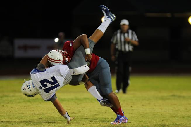 Liberty player Austin Fiaseu (10) lifts up and tackles IMG Academy quarterback Bryson Lucero (12) during a game at Liberty High School, Friday, Sep. 7, 2018.
