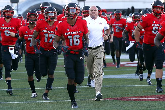 UNLV Head Coach Tony Sanchez, center, take the field with the Rebels before a game against UTEP at Sam Boyd Stadium Saturday, Sept. 8, 2018.