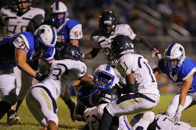 Moapa Valley running back Hayden Redd (42) loses his helmet as he is tackled by Cheyenne players during a game at Moapa Valley High School, Friday, Sep. 14, 2018.