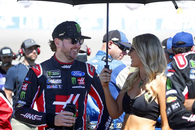 A Monster Energy umbrella girl shades driver Kurt Busch before the start of the South Point 400 NASCAR Cup series race at the Las Vegas Motor Speedway Sunday, Sept. 16, 2018.