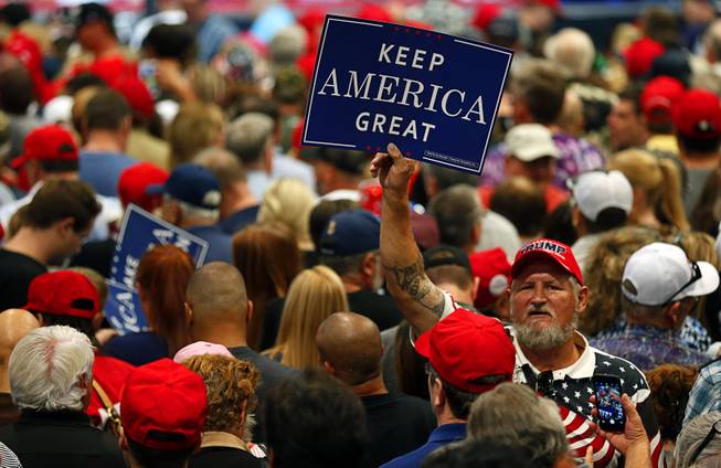 A Trump supporter holds up a sign as he waits for President Donald Trump at a "Make America Great Again (MAGA) rally at the Las Vegas Convention Center Thursday, Sept. 20, 2018.