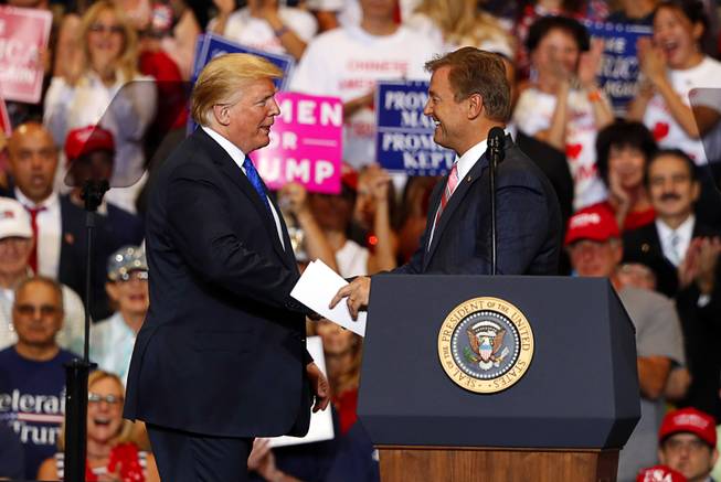President Donald Trump shakes hands with Sen. Dean Heller, R-Nev., during a "Make America Great Again (MAGA) rally at the Las Vegas Convention Center Thursday, Sept. 20, 2018.