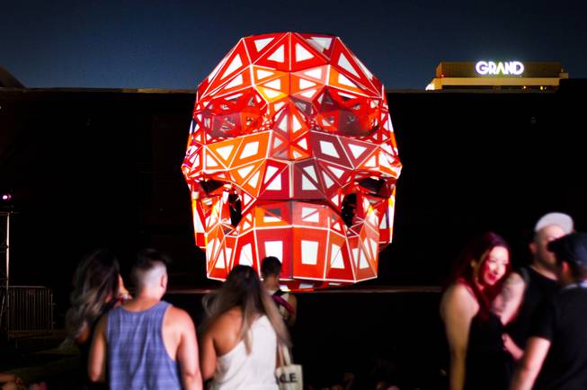 Festivalgoers hang out at the Area 15 promotional large scale projection map skull display during the first day of the Life is Beautiful music festival in downtown Las Vegas, Friday, Sept. 21, 2018.