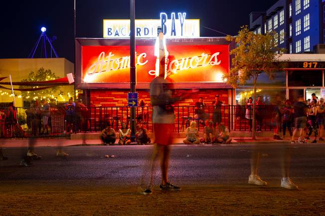 In this time exposure festivalgoers are blurred as they walk past in front of Atomic Liquors bar during the second day of the Life is Beautiful music festival in downtown Las Vegas, Saturday, Sept. 22, 2018.