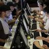 In this July 14, 2018, file photo, people, left, talk to tellers while placing bets at the Meadowlands Racetrack, in East Rutherford, N.J.