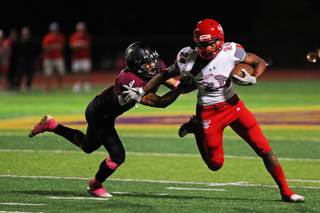 Arbor View running back Daniel Mitchell (24) runs the ball as Faith Lutheran player Sebastian Burke (4) attempts to tackle him during a game at Faith Lutheran High School, Friday, Oct. 5, 2018.