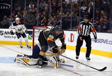 Vegas Golden Knights left wing William Carrier (28) ends up on top of Buffalo Sabres goaltender Carter Hutton (40) after a shot on goal during the third period at T-Mobile Arena Tuesday, Oct. 16, 2018.