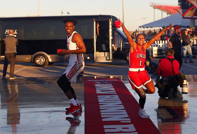 Joel Ntambwe (24) and Kavionnia Brown (1) arrive for an exhibition with the UNLV Runnin' Rebels and Lady Rebels in the parking lot of Sam Boyd Stadium before the UNLV-Air Force football game Friday, Oct. 19, 2018.