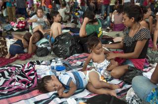A group of migrants rests at the central park in Ciudad Hidalgo, Mexico, Saturday, Oct. 20, 2018. About 2,000 Central American migrants who circumvented Mexican police at a border bridge and swam, forded and floated across the river from Guatemala decided on Saturday to re-form their mass caravan and continue their trek northward toward the United States. (AP Photo/Oliver de Ros)