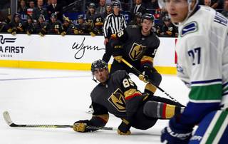 Vegas Golden Knights right wing Alex Tuch (89) slips during overtime against the Vancouver Canucks at T-Mobile Wednesday, Oct. 24, 2018. Vegas Golden Knights center Erik Haula (56) is in the background.