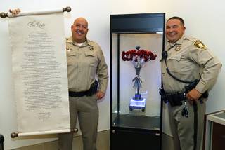 Metro Police Capt. Harry Fagel, left, and Metro Detective Darryl McDonald pose with their artwork during a news conference at Metro Police Headquarters Thursday, Oct. 25, 2018. Fagel holds a a scroll of his poem 