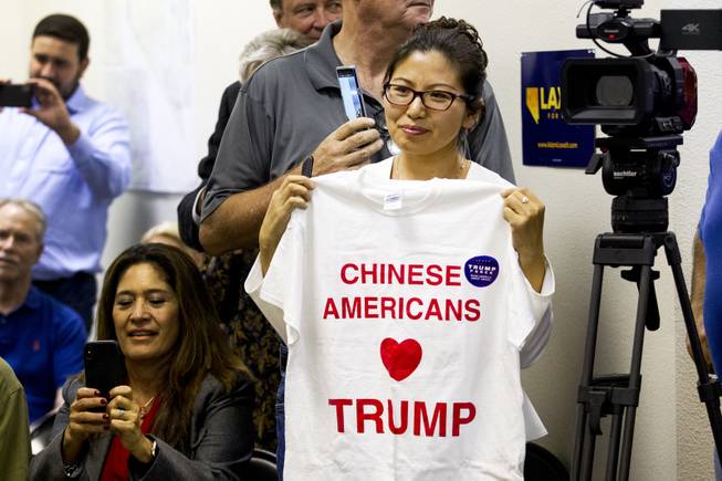 Cynthia Yani Villasenor, President of the Chinese Americans for Trump Movement (CAFT), holds up a "Chinese Americans Heart Trump" t-shirt during a campaign office event, Friday, Oct. 26, 2018.