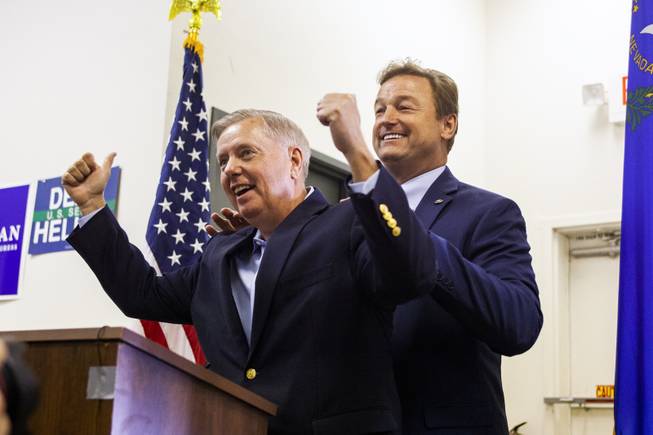 Sen. Dean Heller, R-Nev., right, rubs Sen. Lindsey Graham, R-S.C., shoulders as he introduces him during a campaign office rally, Friday, Oct. 26, 2018.