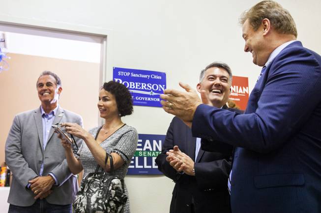 From left: Danny and Amy Tarkanian, Sen. Cory Gardner, R-Colo., and incumbent Republican Sen. Dean Heller react to Sen. Lindsey Graham, R-S.C., not pictured, during a campaign office event, Friday, Oct. 26, 2018.