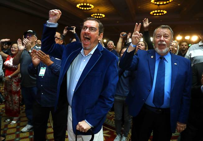 Rick Carrauthers, left, and Dave Tipton cheer a speech by Nevada Democratic Party Chairman William McCurdry II during a Nevada Democrats election night party at Caesars Palace Tuesday, Nov. 6, 2018. 