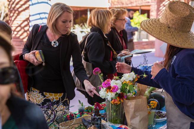 A woman looks to purchase flowers that were grown in the student garden at Fertitta Middle School during the Student Farmers Market at the Clark County Government Center, Thursday Nov. 8, 2018.