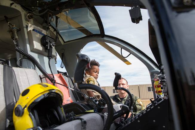 4-year-old Jon'tel Thomas sits in the pilot's seat of an LVMPD helicopter while Sgt. Dave Callen explains how the controls and instruments work, Friday Nov. 16, 2018.