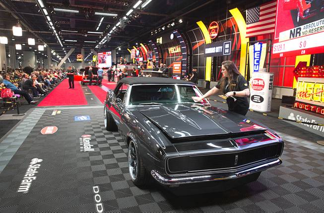 An auction clerk places a "Bid Goes On" sticker on a 1967 Chevrolet Camaro convertible during the second annual Mecum Auctions Las Vegas 2018 at the Las Vegas Convention Center Saturday, Nov. 17, 2018. The Bid Goes On is a program where people can still make offers on vehicles when the reserve was not met.
