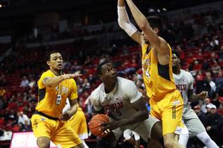 UNLV Rebels forward Cheickna Dembele (15) looks to make a lay up under pressure from Valparaiso Crusader defenders Deion Lavender (2) and Jaume Sorolla (14) during a game at the Thomas & Mack Center Wednesday, Nov. 28, 2018.