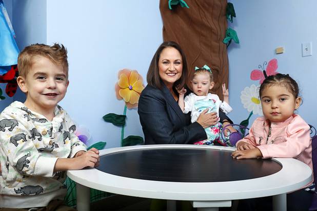 Kelley McClellan, executive director of the Children's Heart Foundation, poses in "Maggie's Garden" in the foundation offices Friday Nov. 30, 2018. With McClellan are Benson Favero, left, 4, Imogen Wolske, 2, and Avie Famularo, 2. The foundation provides emotional, educational, and financial support to children with heart conditions.