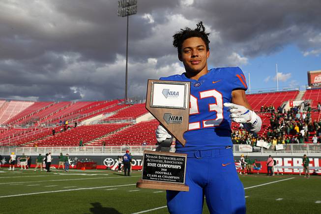 Bishop Gorman running back Amod Cianelli (23) poses with the trophy following Bishop Goman's 69-26 win over Bishop Manogue of Reno in the high school football state championship at Sam Boyd Stadium Saturday, Dec. 1, 2018.