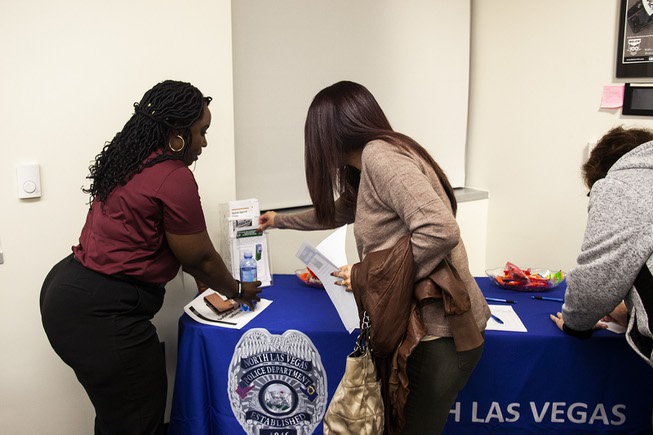 An attendee grabs some information pamphlets during a community safety ...