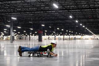Kameron Lurf lays stickers to guide sorting robots during a tour of a new 855,000- square-foot Amazon customer fulfillment facility, in North Las Vegas Thursday, Dec. 6, 2018. This is Amazon's sixth fulfillment center in Nevada and will create over 1,000 full-time jobs when completed.