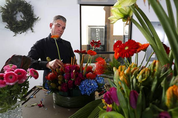 Steven Stewart-Clark works on a floral display at Stinko's, a florist and events business in the Arts District, 1029 S. Main St., Wednesday, Dec. 12, 2018.
