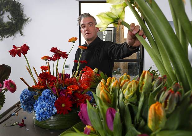 Steven Stewart-Clark works on a floral display at Stinko's, a florist and events business in the Arts District, 1029 S. Main St., Wednesday, Dec. 12, 2018.
