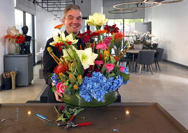 Steven Stewart-Clark poses after completing a floral display at Stinko's, a florist and events business in the Arts District, 1029 S. Main St., Wednesday, Dec. 12, 2018.