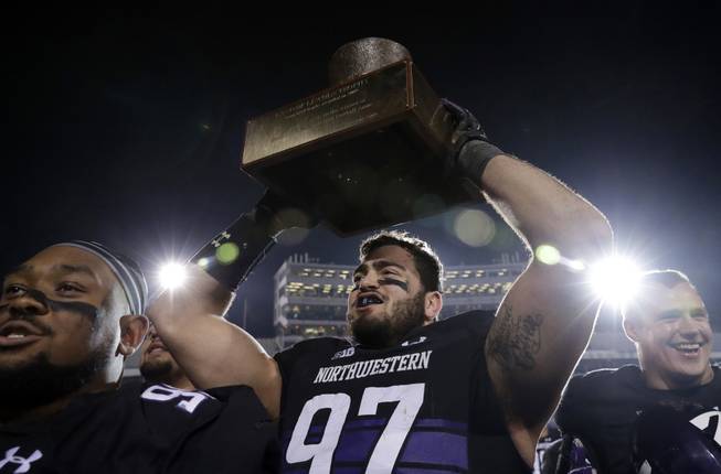 Northwestern defensive lineman Joe Gaziano, center, celebrates with teammates as he holds the Land of Lincoln Trophy after Northwestern defeated Illinois 24-16 in Evanston, Ill., Saturday, Nov. 24, 2018. 