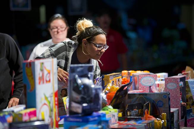 Solene Villanueva looks over a table of toys during the Salvation Army's Christmas Angel program at the Silver Nugget Events Center in North Las Vegas Friday, Dec. 14, 2018.