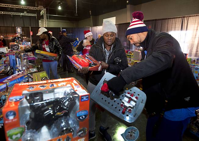 Jewell Webb land her husband Lafeeha Webb pick out toys during the Salvation Army's Christmas Angel program at the Silver Nugget Events Center in North Las Vegas Friday, Dec. 14, 2018. In addition to their own children, they have also been raising Jewell's sister's children after the sister passed away.