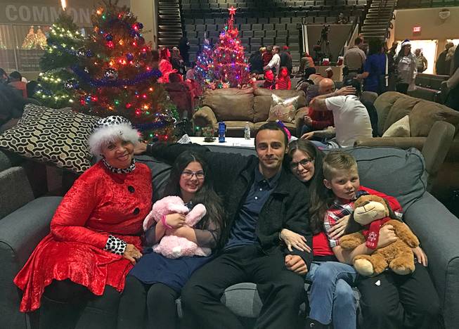 Inmate John Muhlhouser, center, puts his arms around girlfriend Amber Perry and stepchildren Lavinia and Lucas during a Christmas event for prisoners and their families at The Crossings Christian Church on Thursday, Dec. 13, 2018. On the left, Hope for Prisoners volunteer Marjorie Jones met the family for the first time Thursday night.